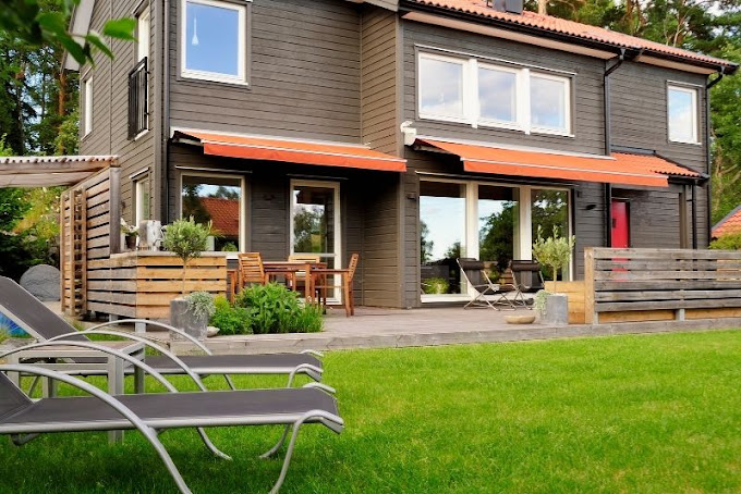 Outdoor patio decorated with furniture, cushions and string lighting
