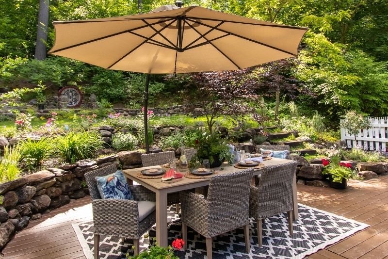 dining table and chairs with an umbrella on an outdoor patio