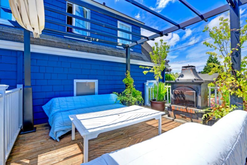 open pergola attached to a house painted blue